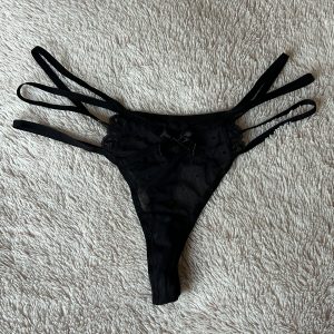 Getragener schwarzer Tanga, schön mit kleinen Herzen
